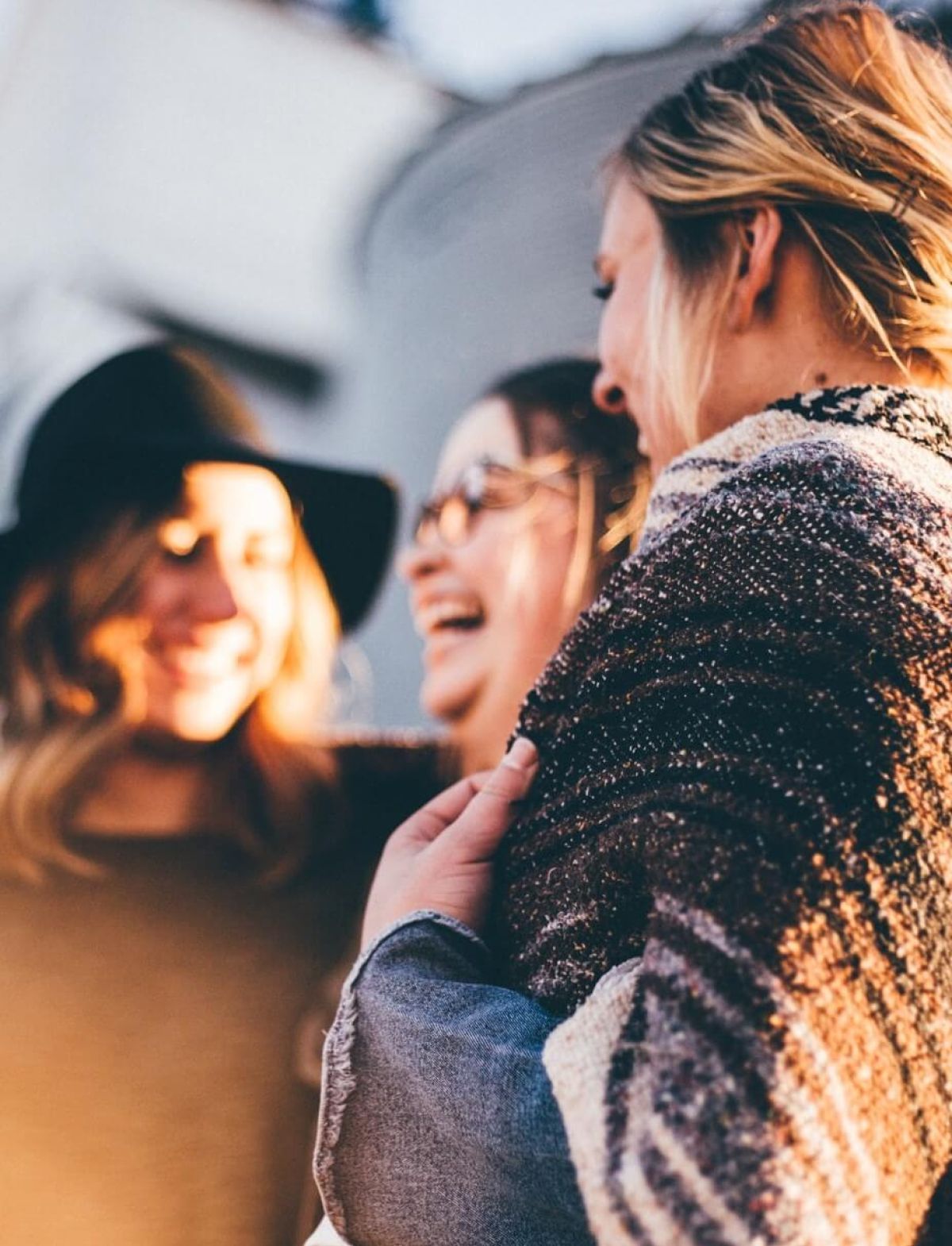 Drei lachende Frauen, die zusammen stehen